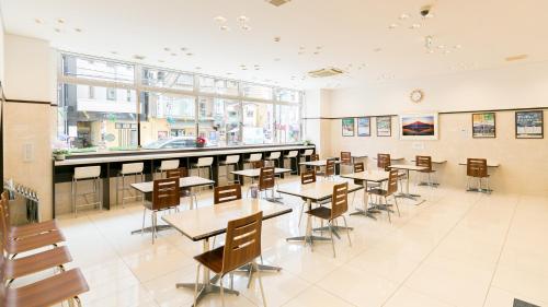 鹿兒島的住宿－Toyoko Inn Kagoshima chuo eki Nishi guchi，餐厅内带桌椅的用餐室