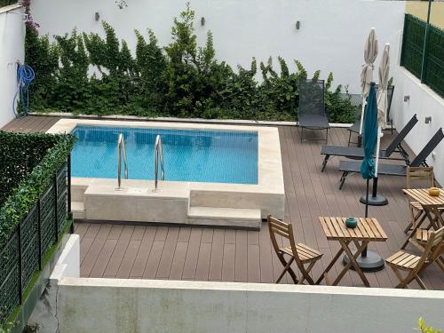 a swimming pool with chairs and a table at Saldanha Pool & Garden in Lisbon