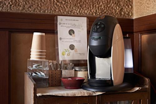 a black coffee maker sitting on top of a shelf at Yamada Bessou くつろぎの温泉宿 山田別荘 in Beppu