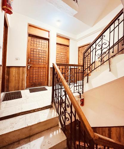 a staircase in a house with a wooden door at Hotel Snow Mountain Mall Road in Manāli