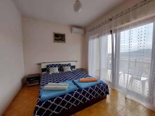 a bedroom with a bed and a large window at Apartment Robi in Bribir