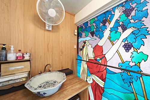 a bathroom with a shower with a sink and a fan at Yamada Bessou くつろぎの温泉宿 山田別荘 in Beppu