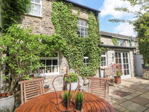 a patio with a table and chairs in front of a building at Chandler House in Castleton