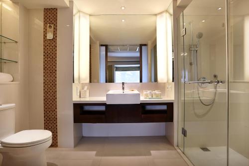 a bathroom with a sink and a toilet and a shower at Novotel Lombok Resort & Villas in Kuta Lombok