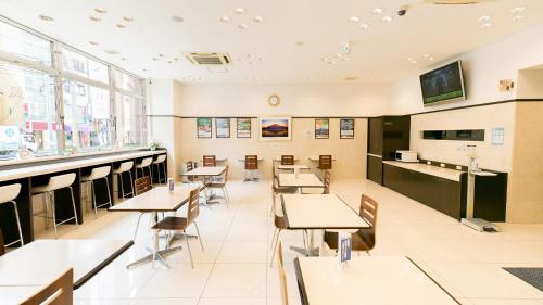 une salle de classe avec des tables et des chaises dans une cafétéria dans l'établissement Toyoko Inn Kagoshima chuo eki Higashi guchi, à Kagoshima