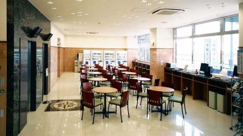une salle à manger avec des tables et des chaises dans un restaurant dans l'établissement Toyoko Inn Kitakyushu Airport, à Kitakyūshū