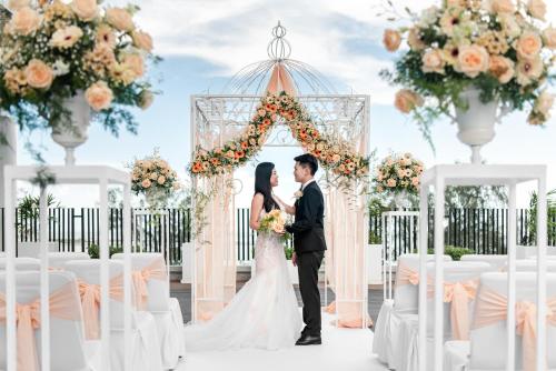 a bride and groom standing in front of a wedding arch at Ascott Gurney Penang in George Town