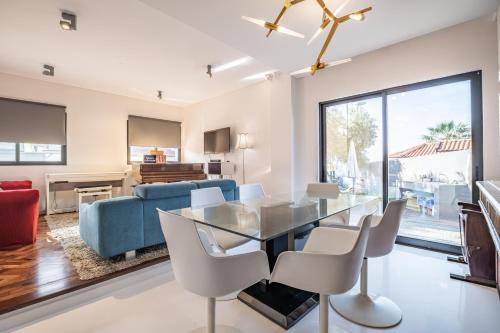 a dining room and living room with a glass table and chairs at Casa Familiar 3 Quartos in Funchal