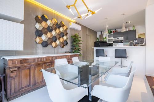 a dining room with a glass table and white chairs at Casa Familiar 3 Quartos in Funchal