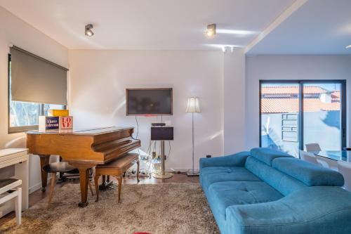 a living room with a blue couch and a piano at Casa Familiar 3 Quartos in Funchal