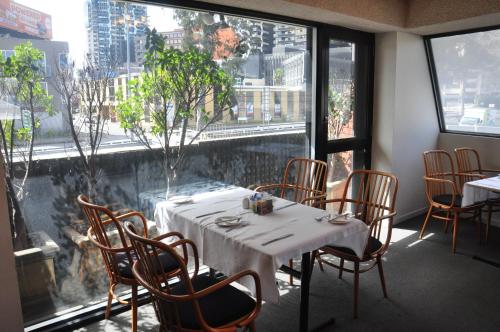 a dining room table with chairs and a window at City Park Hotel in Melbourne