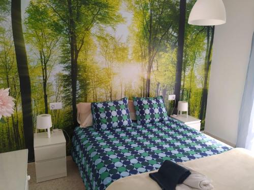 a bedroom with a bed with a painting of trees at Casa el Anden 11 in El Bosque
