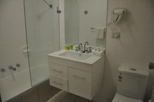 a bathroom with a sink and a shower and a toilet at City Park Hotel in Melbourne