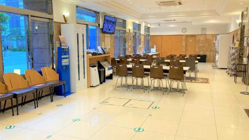 Habitación grande con mesas y sillas. en Toyoko Inn Hakata-guchi Ekimae, en Fukuoka