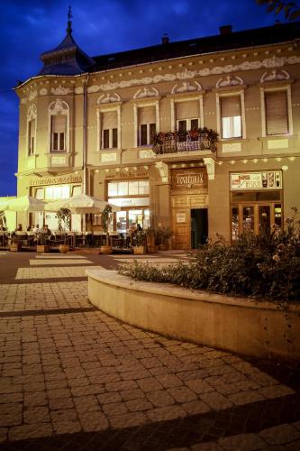 a large building on a street at night at La Pergola & Prestige Panzió in Kaposvár