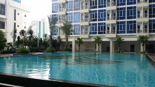 a large swimming pool in front of a building at Capitol Park Minimum Stay 2 Nights in Jakarta