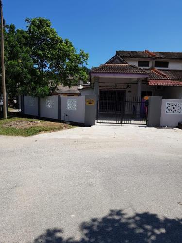 a house with a gate in front of a driveway at D'Salbiah Homestay in Kemaman