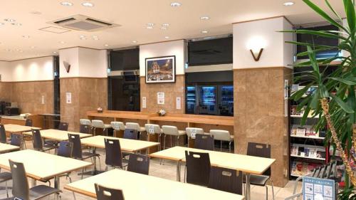 Toyoko Inn Hakata Nishi-nakasu في فوكوكا: منطقة طعام مع طاولات وكراسي في مطعم