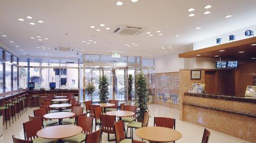 a restaurant with tables and chairs in a cafeteria at Toyoko Inn Hakata-eki Bus Terminal Mae in Fukuoka