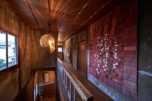 a staircase in a house with a painting on the wall at Yamada Bessou くつろぎの温泉宿 山田別荘 in Beppu