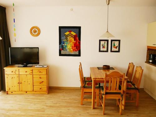 a dining room with a table and a television at Ferienwohnung Plexnies in Kellenhusen