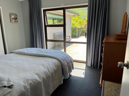 a bedroom with a bed and a sliding glass door at Family Home on Inverness in Arrowtown