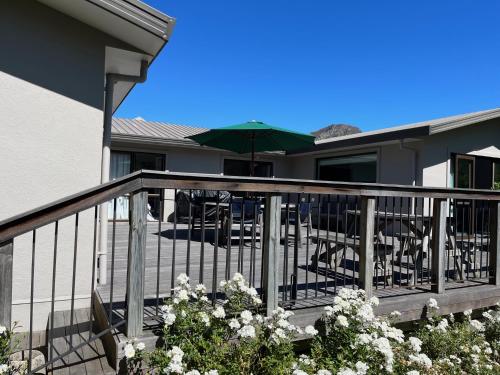 a balcony with a table and an umbrella at Family Home on Inverness in Arrowtown