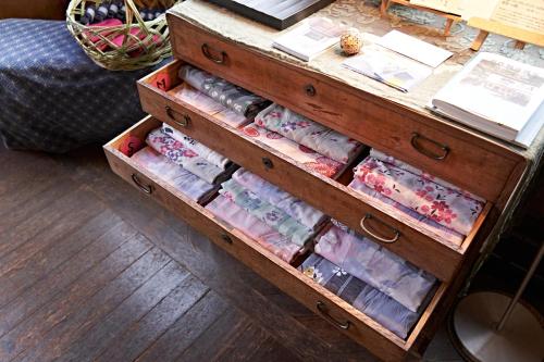 a wooden dresser with drawers full of ties at Yamada Bessou くつろぎの温泉宿 山田別荘 in Beppu