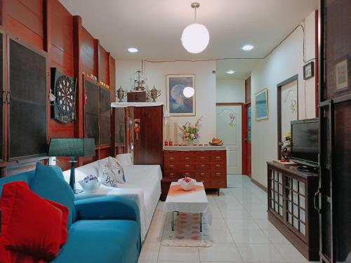 a living room with a blue couch and a tv at บาคัสโฮมลอร์ด in Haad Chao Samran