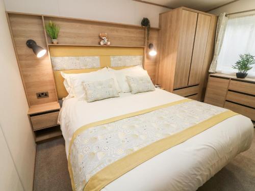 a bedroom with a large bed with a wooden headboard at Langdale Lodge in Carnforth