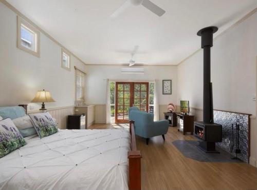 a bedroom with a large bed and a fireplace at Barney Creek Vineyard Cottages in Barney View