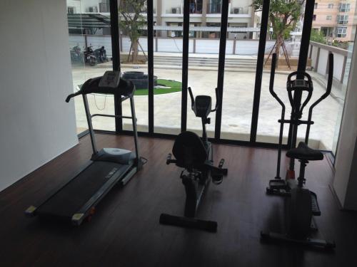 a gym with three treadmills and a window at Me 2 Kamphangsaen in Kamphaeng Saen