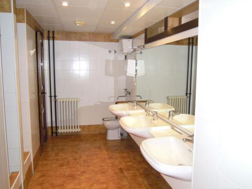 a bathroom with three sinks and a toilet at Albergue Albarracín in Albarracín