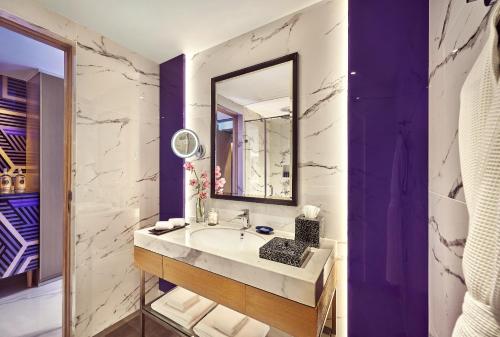 La salle de bains est pourvue d'un lavabo et d'un miroir. dans l'établissement Vivanta Navi Mumbai Turbhe, à Navi Mumbai