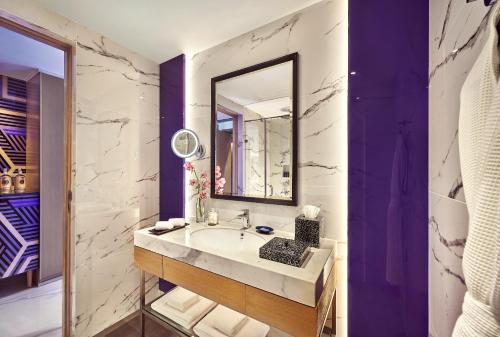 a bathroom with a sink and a mirror at Vivanta Navi Mumbai Turbhe in Navi Mumbai