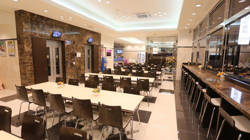 Toyoko Inn Tsushima Izuhara في تسوشيما: قاعة احتفالات مع طاولات وكراسي في مطعم
