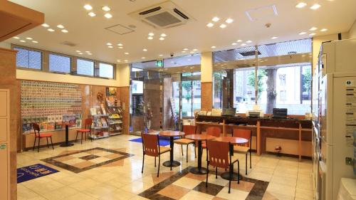 熊本市にある東横INN熊本桜町バスターミナル前の建物の中にテーブルと椅子があるレストラン