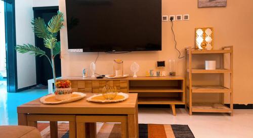 ein Wohnzimmer mit einem TV und einem Couchtisch in der Unterkunft Raspberry in Abha