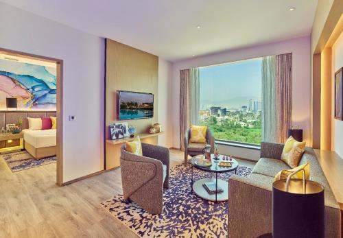 a living room with purple walls and a large window at Vivanta Navi Mumbai Turbhe in Navi Mumbai