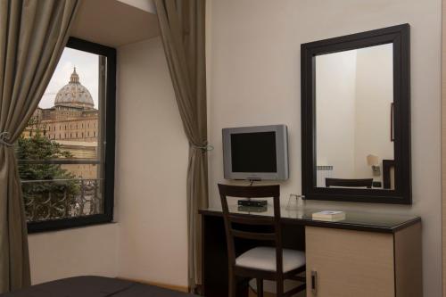 Zimmer mit einem Schreibtisch, einem Spiegel und einem TV. in der Unterkunft My Rooms in Rom