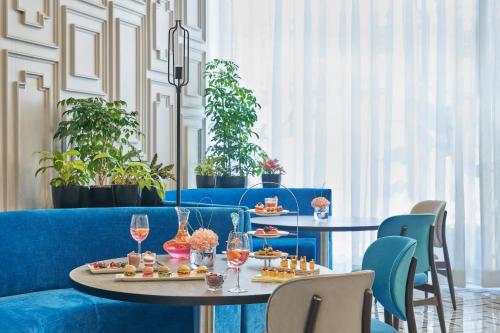 a restaurant with two tables with food and wine glasses at Vivanta Navi Mumbai Turbhe in Navi Mumbai