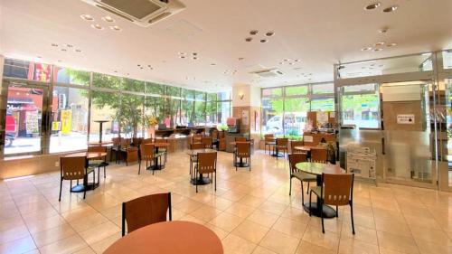 熊本市にある東横INN熊本新市街のテーブルと椅子、窓のあるレストラン