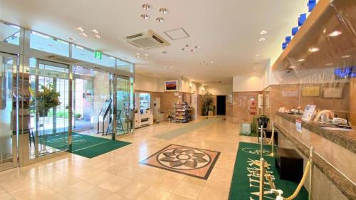 a large room with a lobby with a green carpet at Toyoko Inn Kumamoto Shin-shigai in Kumamoto