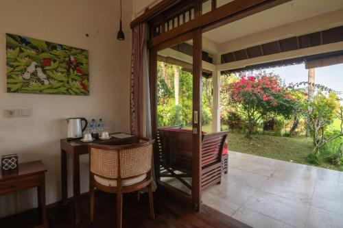a dining room with a table and a glass door at Lesong Hotel and Restaurant in Munduk