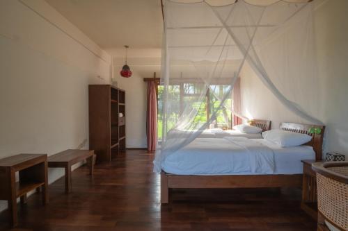 a bedroom with a bed with a mosquito net at Lesong Hotel and Restaurant in Munduk