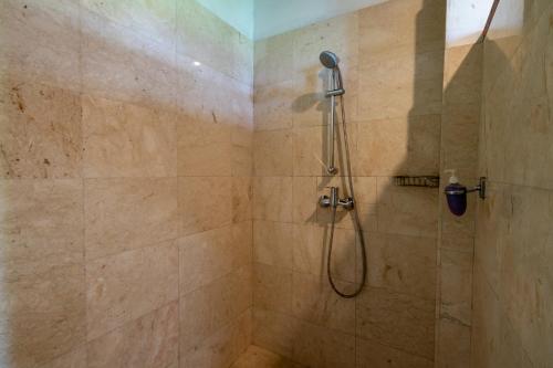 a bathroom with a shower with a shower head at Lesong Hotel and Restaurant in Munduk