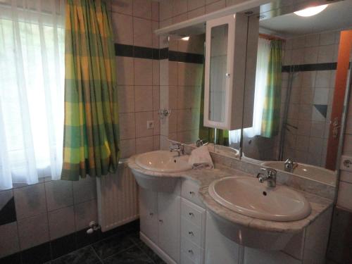 a bathroom with two sinks and a mirror at Haus Toferer in Grossarl