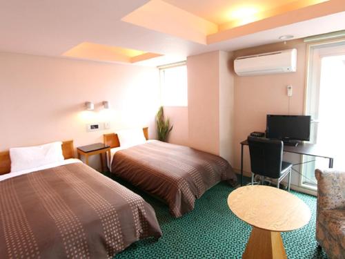 HOTEL LiVEMAX BUDGET Yumoto في إيواكي: غرفة فندقية بسريرين وتلفزيون بشاشة مسطحة