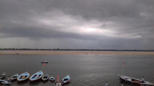 a group of boats in the water under a cloudy sky at MONALISA HOSTEL in Varanasi