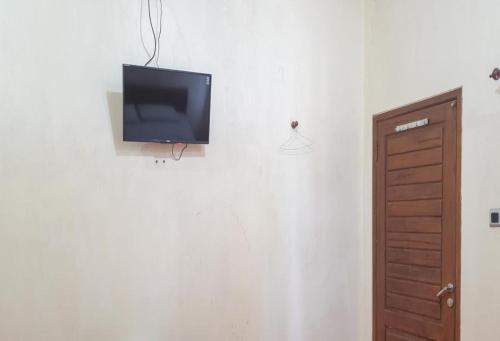 a flat screen tv on a wall in a room at Hotel Mataram Cipanas Syariah Mitra RedDoorz in Pasakon 1